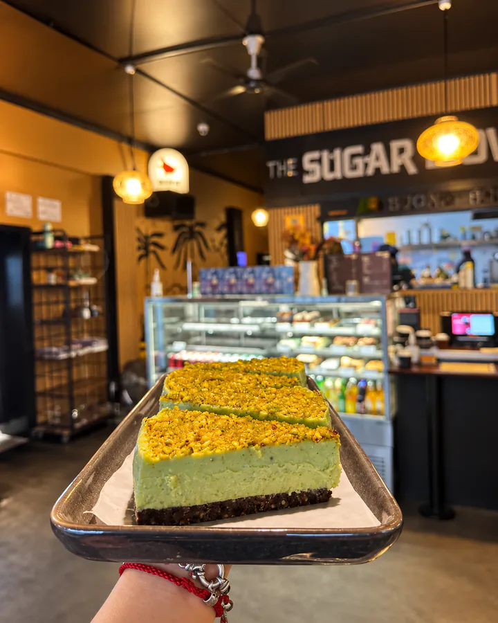 A tray of sweet slices held in front of The Sugar Bowl Cafe counter